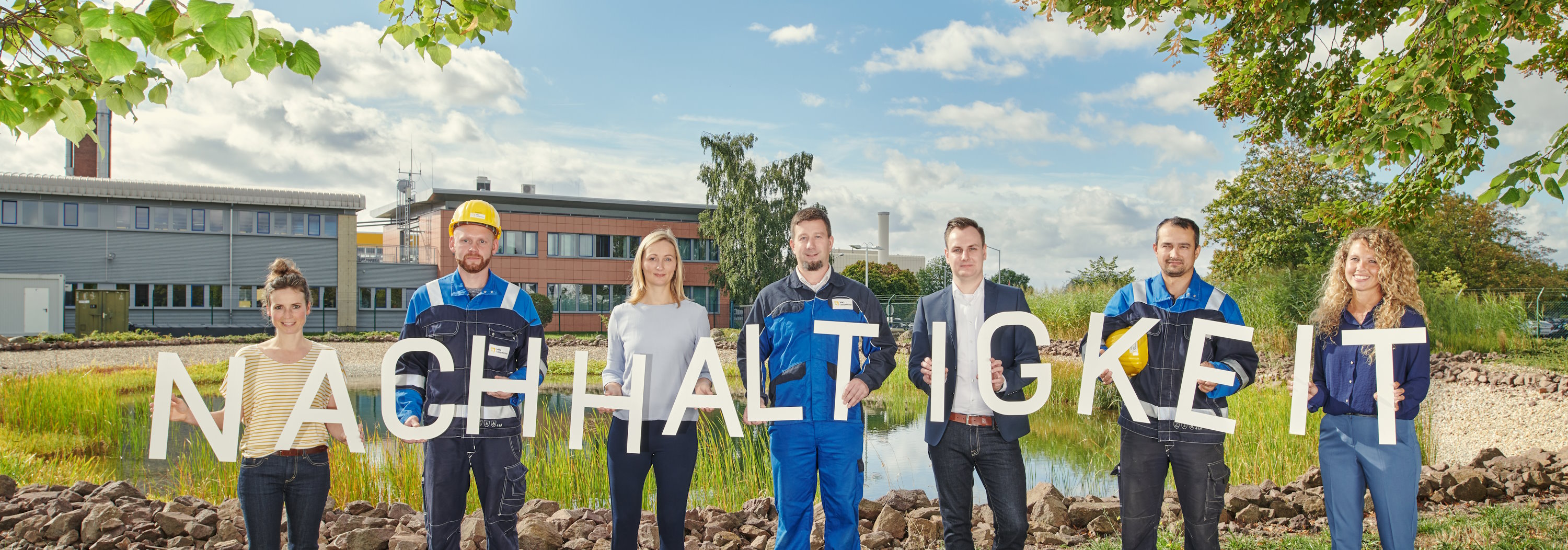 Personen halten Buchstaben in die Luft, die das Wort Nachhaltigkeit ergeben